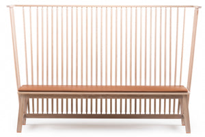 A modern wooden bench with a tall slatted backrest, angled legs, and a brown cushioned seat, shown against a plain white background.