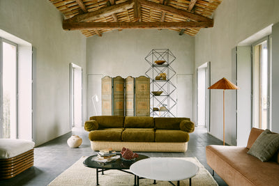 Modern living room with a green sofa, coffee table, and decorative items.