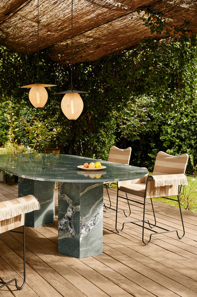 Outdoor setting with a marble table and chairs under a wooden canopy.