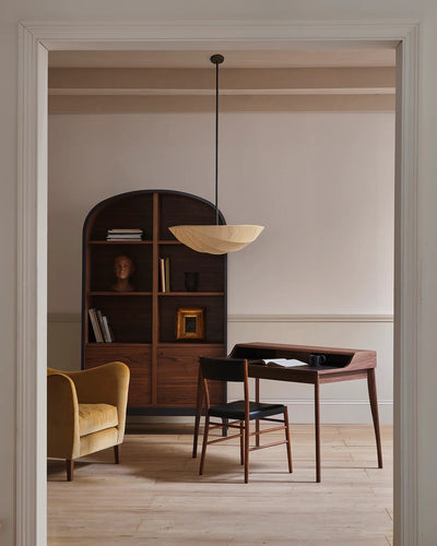 Modern interior with wooden furniture, bookshelf, and pendant light.